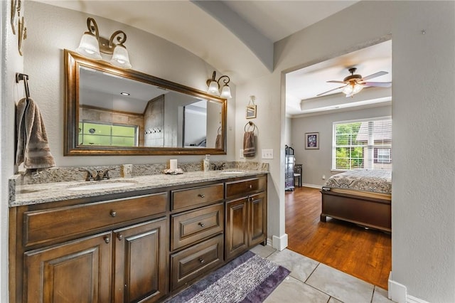 ensuite bathroom with tile patterned flooring, double vanity, a ceiling fan, connected bathroom, and a sink
