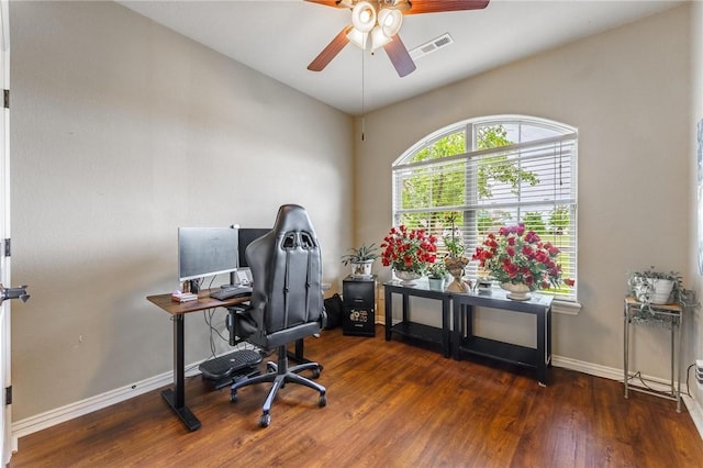 home office featuring visible vents, a ceiling fan, baseboards, and wood finished floors
