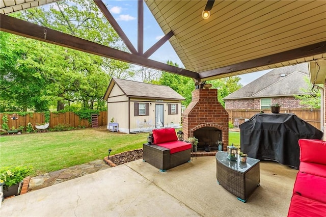 view of patio featuring an outdoor structure, a fenced backyard, and an outdoor brick fireplace