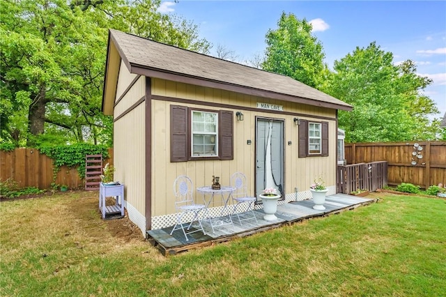 view of outdoor structure with a fenced backyard and an outbuilding