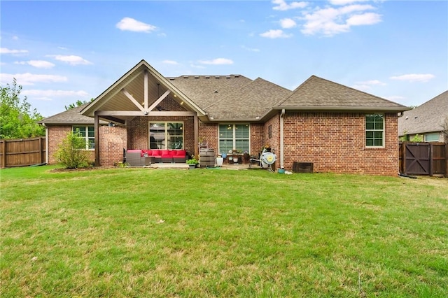 back of house with outdoor lounge area, a patio, a fenced backyard, brick siding, and a yard