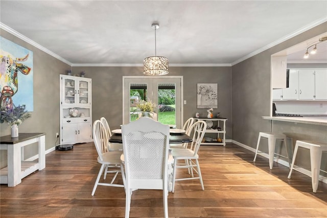 dining room featuring baseboards, ornamental molding, and dark wood-style floors