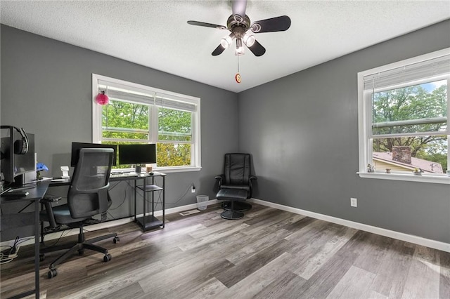 office space featuring baseboards, a textured ceiling, ceiling fan, and wood finished floors