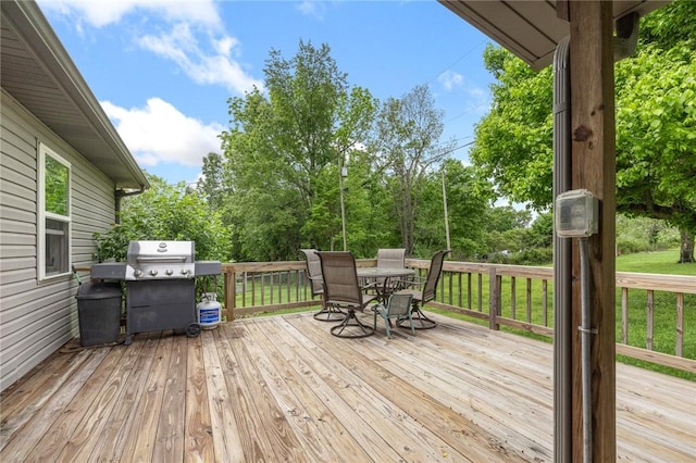deck with a lawn, outdoor dining area, and area for grilling
