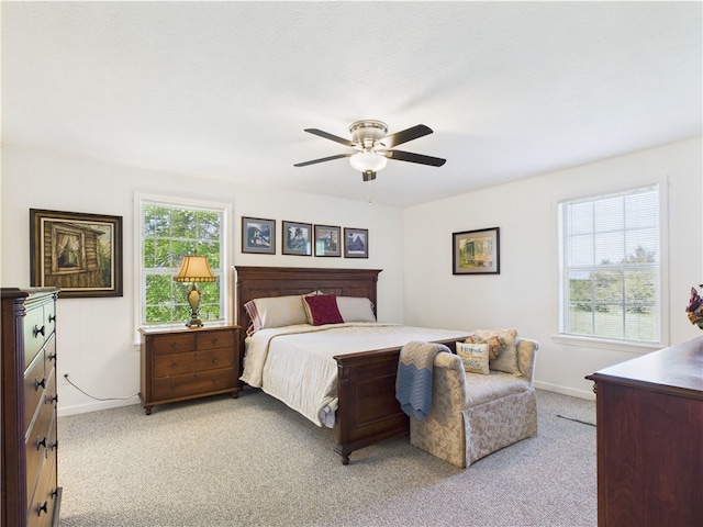 bedroom with baseboards, a ceiling fan, and light colored carpet