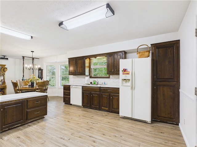 kitchen featuring light countertops, dark brown cabinetry, white appliances, and light wood-style flooring