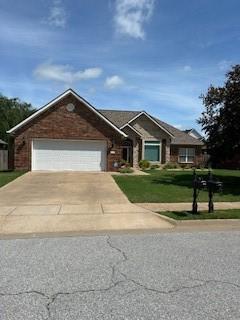 view of front facade with a garage, concrete driveway, and a front yard