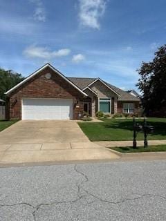 view of front facade with concrete driveway, a front yard, and a garage