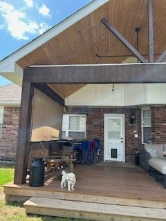 rear view of house with brick siding and a deck