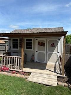 rear view of property with a storage unit and an outdoor structure