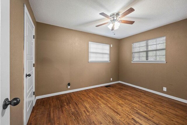 empty room with baseboards, a textured ceiling, ceiling fan, and wood finished floors