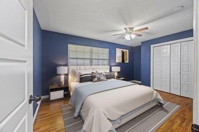 bedroom with a ceiling fan, a textured ceiling, wood finished floors, baseboards, and a closet