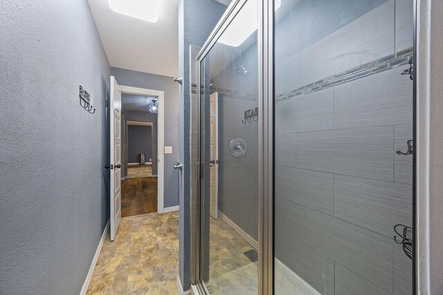 full bathroom with baseboards and a shower stall