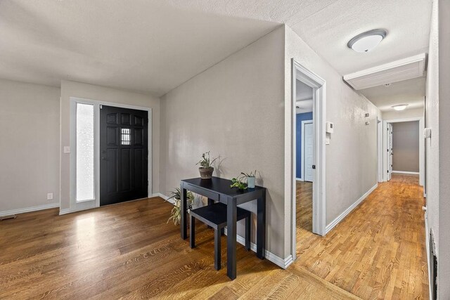entrance foyer with baseboards and light wood-style floors
