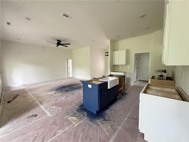 kitchen featuring blue cabinets, ceiling fan, white cabinets, and visible vents