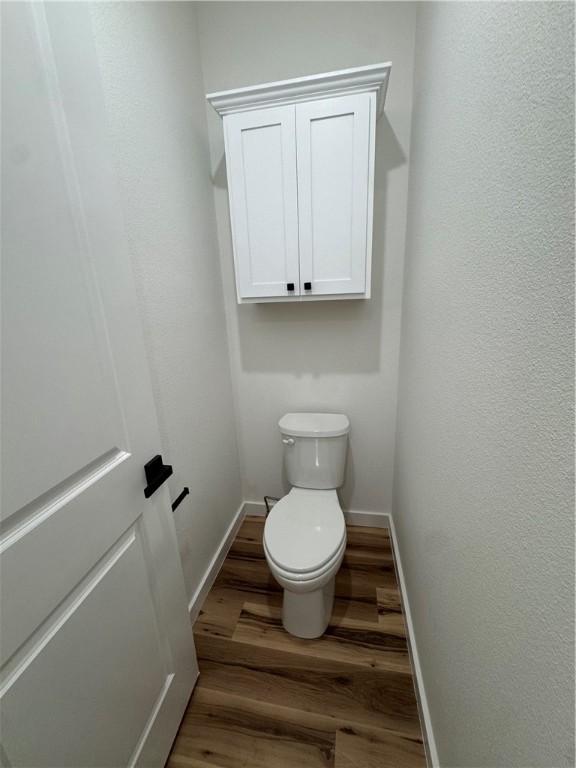 13537 Little Elm Rd, Farmington, AR 72730 - bathroom with wood finished floors, toilet, and baseboards
