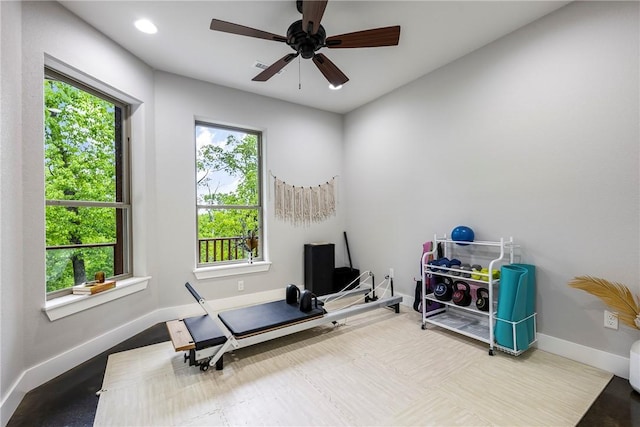exercise area with baseboards and a ceiling fan