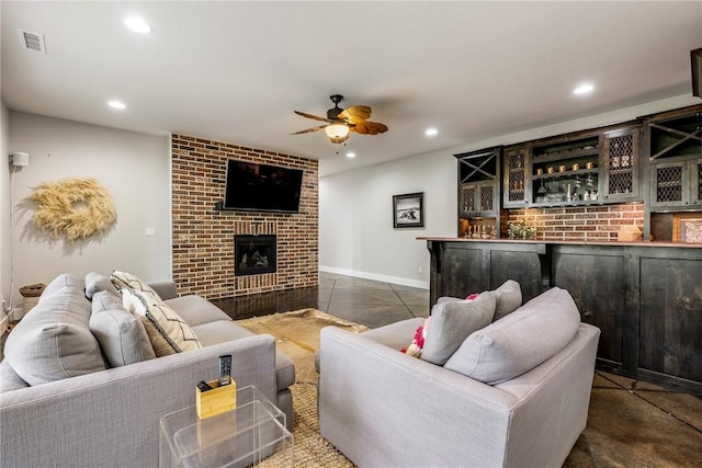 living area with a ceiling fan, visible vents, a dry bar, a fireplace, and recessed lighting