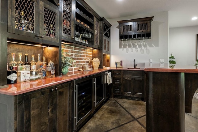 bar with decorative backsplash, wet bar, finished concrete flooring, a sink, and beverage cooler
