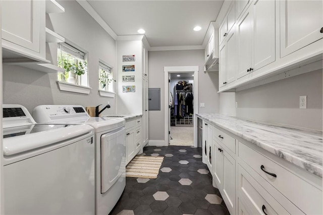 laundry area featuring ornamental molding, washing machine and dryer, recessed lighting, electric panel, and cabinet space