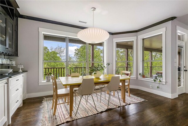 dining area with baseboards, visible vents, a healthy amount of sunlight, and dark wood-type flooring