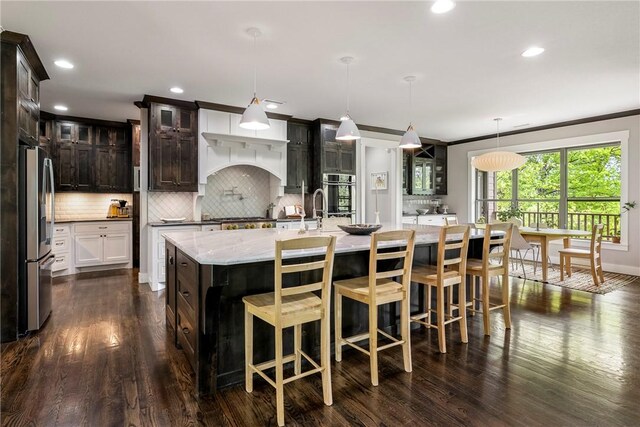 kitchen with appliances with stainless steel finishes, recessed lighting, tasteful backsplash, a spacious island, and glass insert cabinets