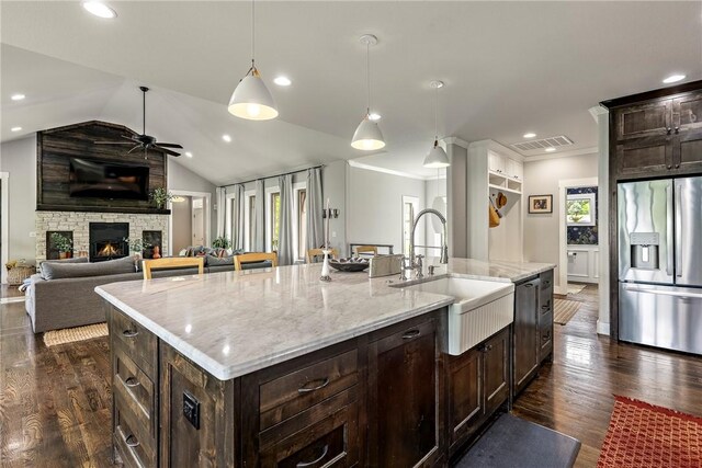 kitchen featuring a sink, stainless steel fridge with ice dispenser, dark brown cabinetry, and dark wood finished floors