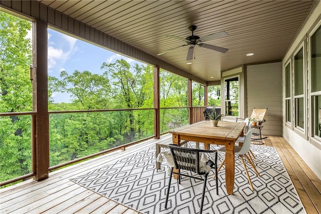 sunroom featuring a ceiling fan and outdoor dining area