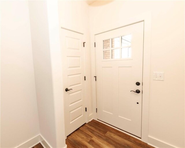 doorway to outside with baseboards and dark wood finished floors