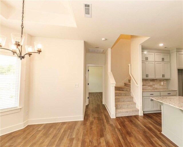 kitchen with visible vents, decorative backsplash, an inviting chandelier, and wood finished floors