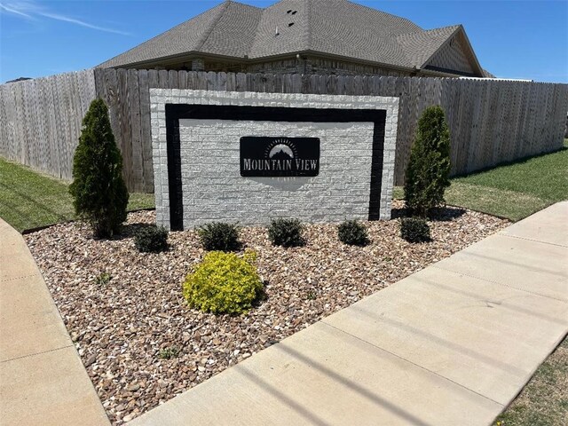 community sign featuring a garage and fence