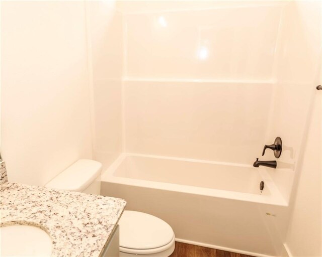 bathroom with toilet, bathtub / shower combination, wood finished floors, and vanity