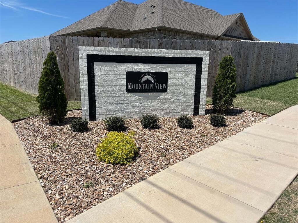 community sign featuring a garage and fence