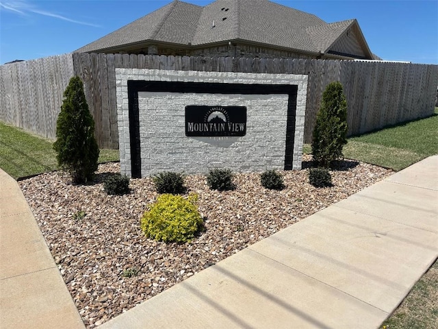community sign featuring a garage and fence