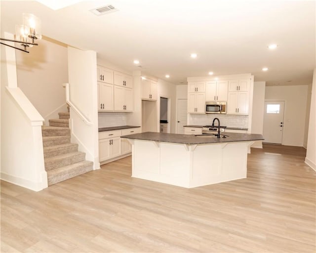 212 Nebo St, Prairie Grove, AR 72753 - kitchen with stainless steel microwave, a sink, dark countertops, and visible vents