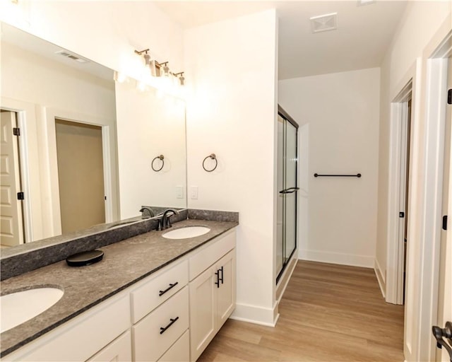 212 Nebo St, Prairie Grove, AR 72753 - bathroom featuring a shower stall, double vanity, a sink, and wood finished floors
