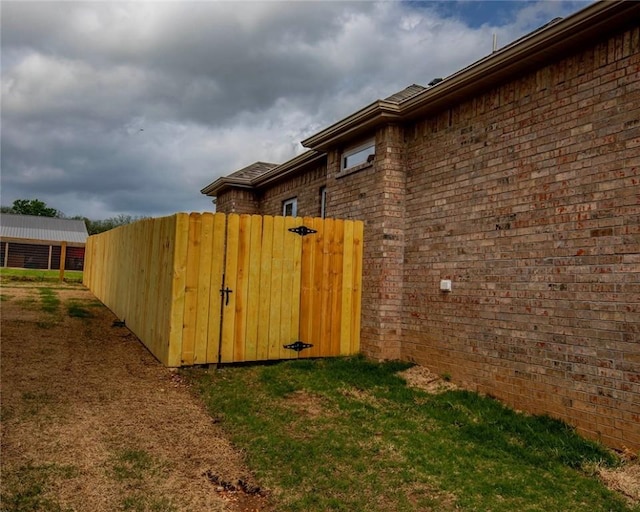 212 Nebo St, Prairie Grove, AR 72753 - view of property exterior with brick siding, a gate, and fence