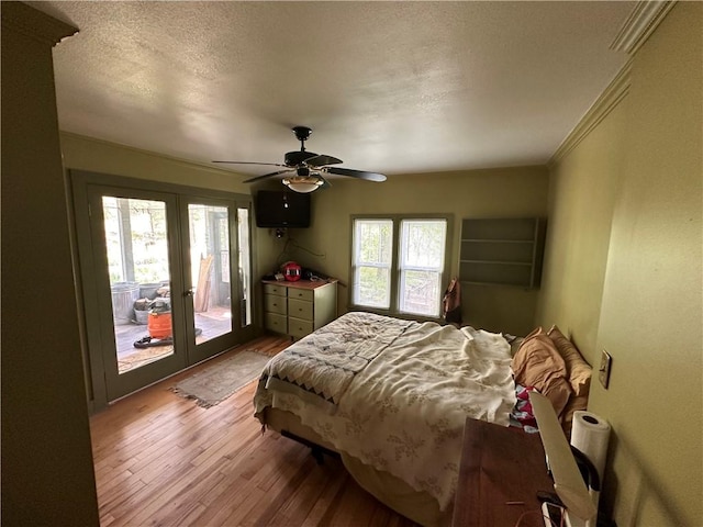 bedroom featuring crown molding, ceiling fan, a textured ceiling, access to exterior, and wood finished floors