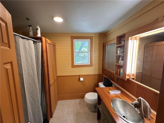 bathroom featuring wooden walls, vanity, a closet, and toilet