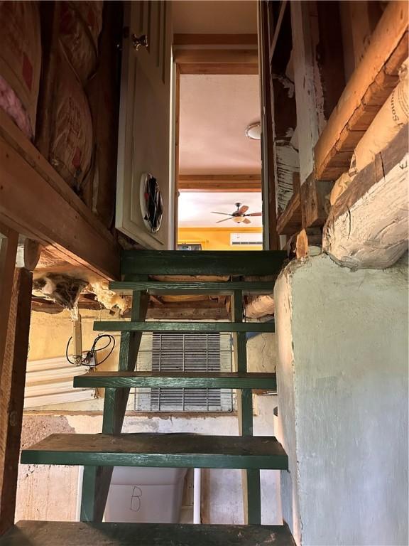 stairway featuring a ceiling fan