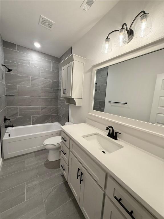 bathroom featuring visible vents, shower / bath combination, toilet, and vanity