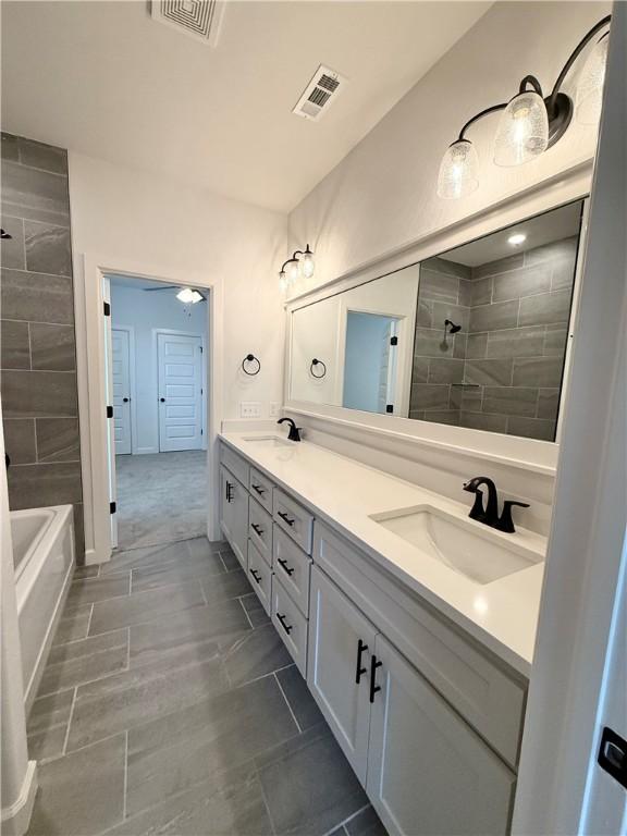 full bathroom with visible vents, a sink, and double vanity