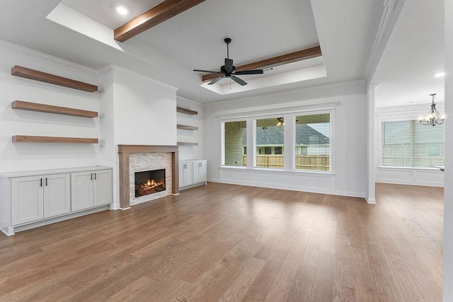 909 Budrio Ave, Tontitown, AR 72762 - unfurnished living room featuring ceiling fan, a warm lit fireplace, wood finished floors, a chandelier, and beam ceiling