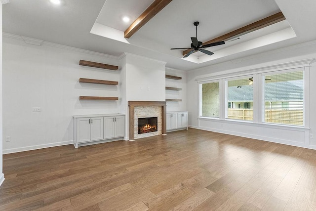 909 Budrio Ave, Tontitown, AR 72762 - unfurnished living room featuring ceiling fan, a fireplace, wood finished floors, a tray ceiling, and baseboards