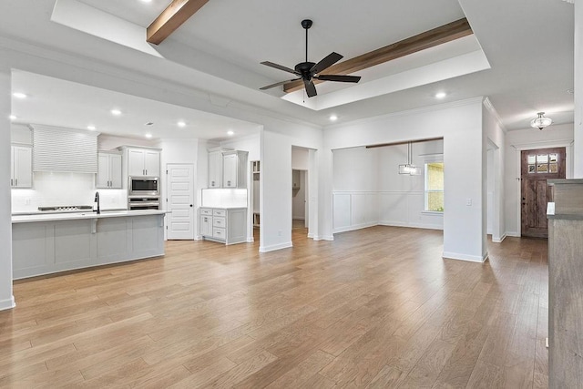 909 Budrio Ave, Tontitown, AR 72762 - unfurnished living room with ceiling fan, recessed lighting, a raised ceiling, light wood-style flooring, and crown molding