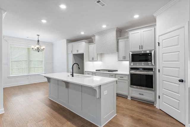909 Budrio Ave, Tontitown, AR 72762 - kitchen featuring appliances with stainless steel finishes, a sink, a chandelier, decorative backsplash, and light countertops