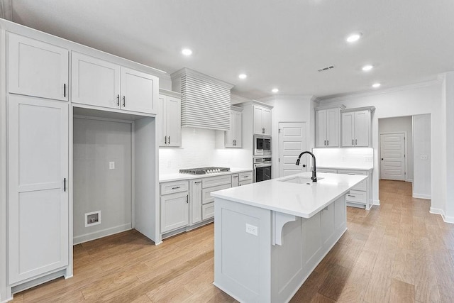 909 Budrio Ave, Tontitown, AR 72762 - kitchen featuring a sink, appliances with stainless steel finishes, ornamental molding, decorative backsplash, and a kitchen island with sink