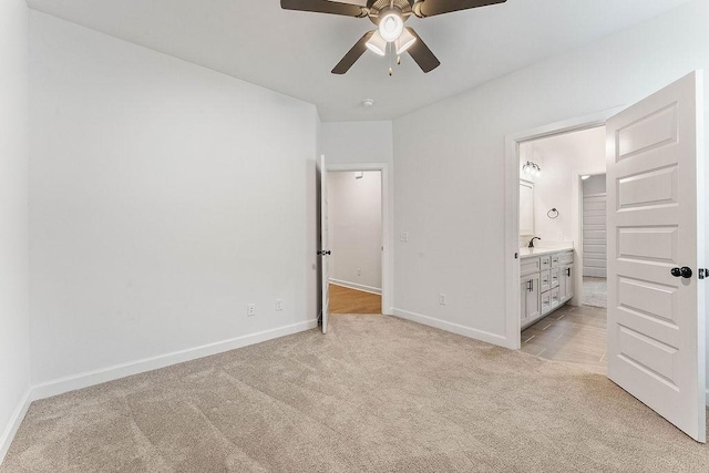 909 Budrio Ave, Tontitown, AR 72762 - unfurnished bedroom with light carpet, baseboards, connected bathroom, a sink, and ceiling fan