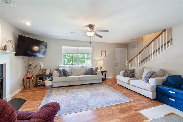 5213 S 62nd St, Rogers, AR 72758 - living area with wood finished floors, ceiling fan, stairs, baseboards, and a fireplace with flush hearth