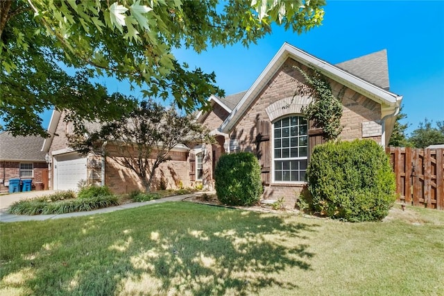 view of front of property with fence, stone siding, brick siding, a front yard, and driveway